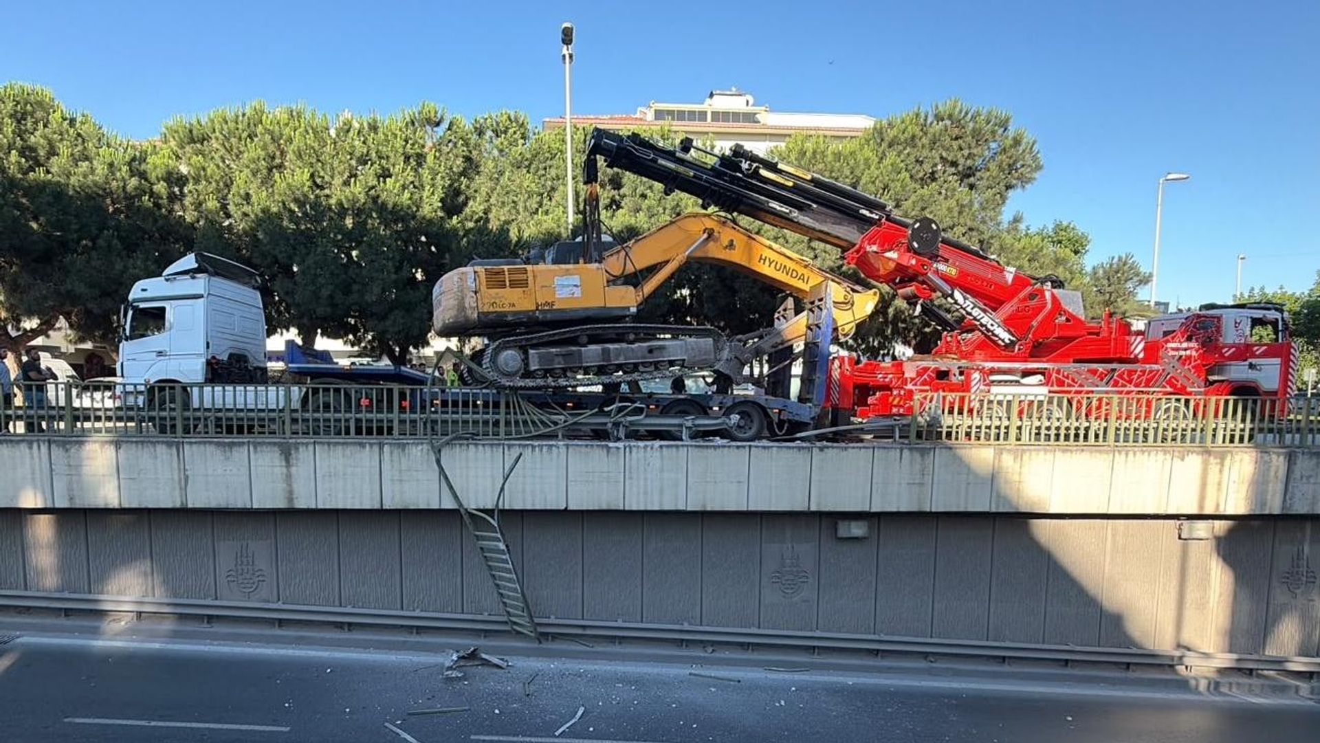 Seyir halindeki TIR'ın üzerinden düşen ekskavatör korkuluklarda asılı kaldı